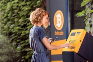 Eine Frau steht vor einem Bitcoin ATM