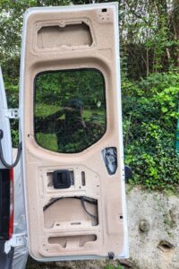 ZU sehen ist die Innenseite einer aufgeklapten Hecktüre eines Campers, die mit Sprühkork verkleidet wurde