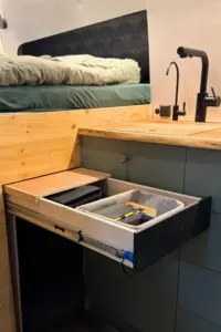 ein halb offener ausziehbarer Schreibtisch mit integriertem Stauraum für Büromaterial