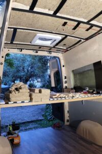 Die Decke eines noch leeren Campervans wird mit Schafwolle gedämmt