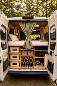 Ordnung im Camper mit Boxen, Fächern und Gepäcknetzen in der organisierten Heckgarage eines Campervans
